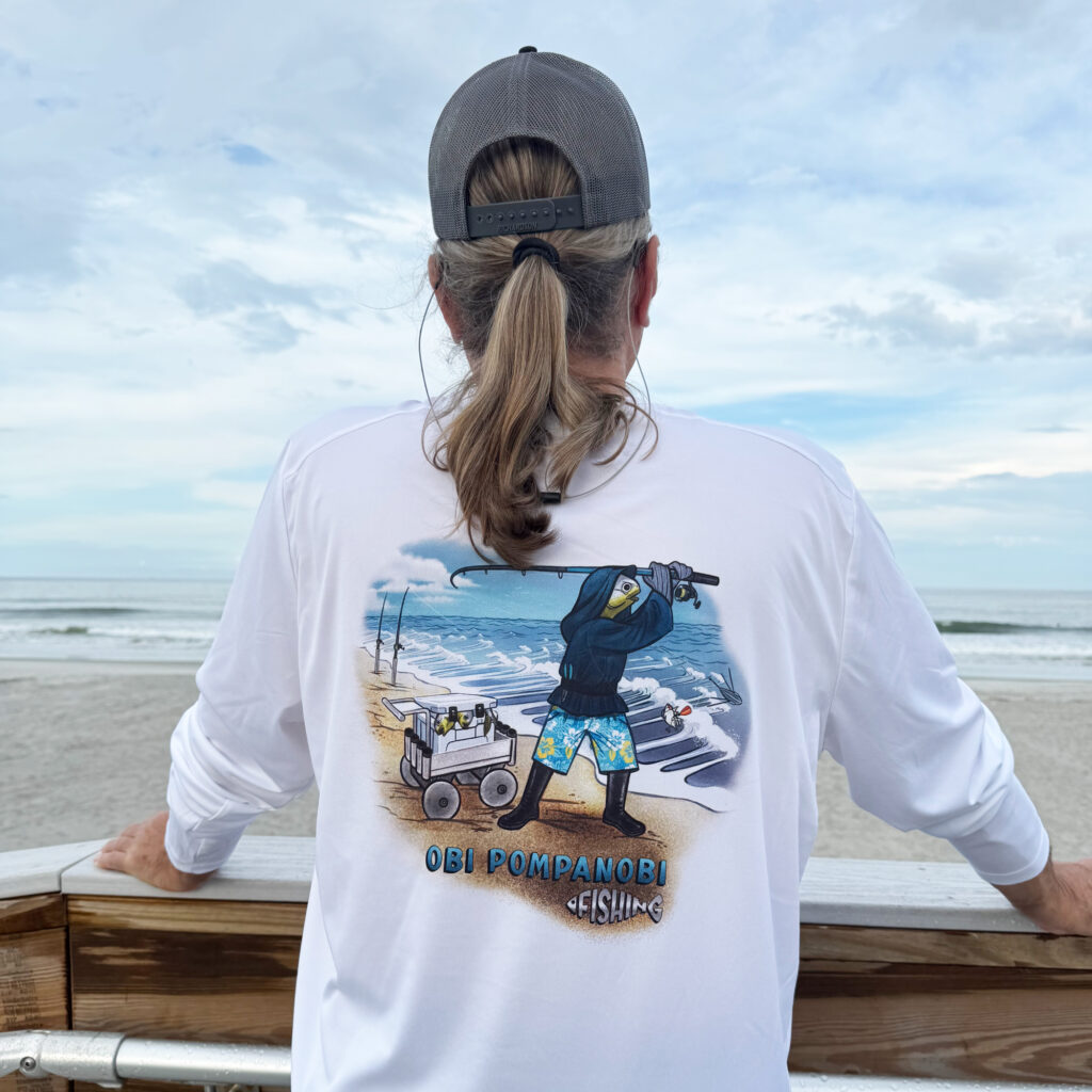 Dorman on beachwalk wearingSport-tec performance Tee looking at ocean